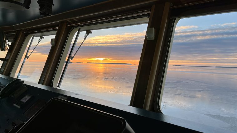 Bilden visar utsikten från båtens brygga. Sol och hav.